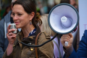 A woman speaking with a megaphone at the protest.