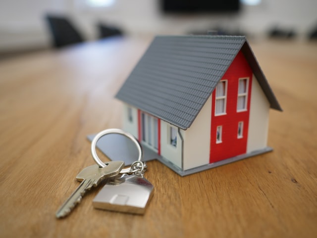 A small model of a house with keys beside it