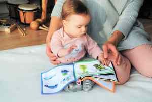 A baby playing with a textured book