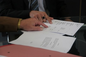 People signing contracts.