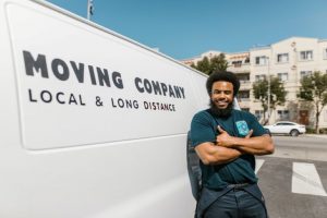A professional mover standing next to a moving van.