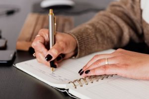 A woman writing a plan<script async src=